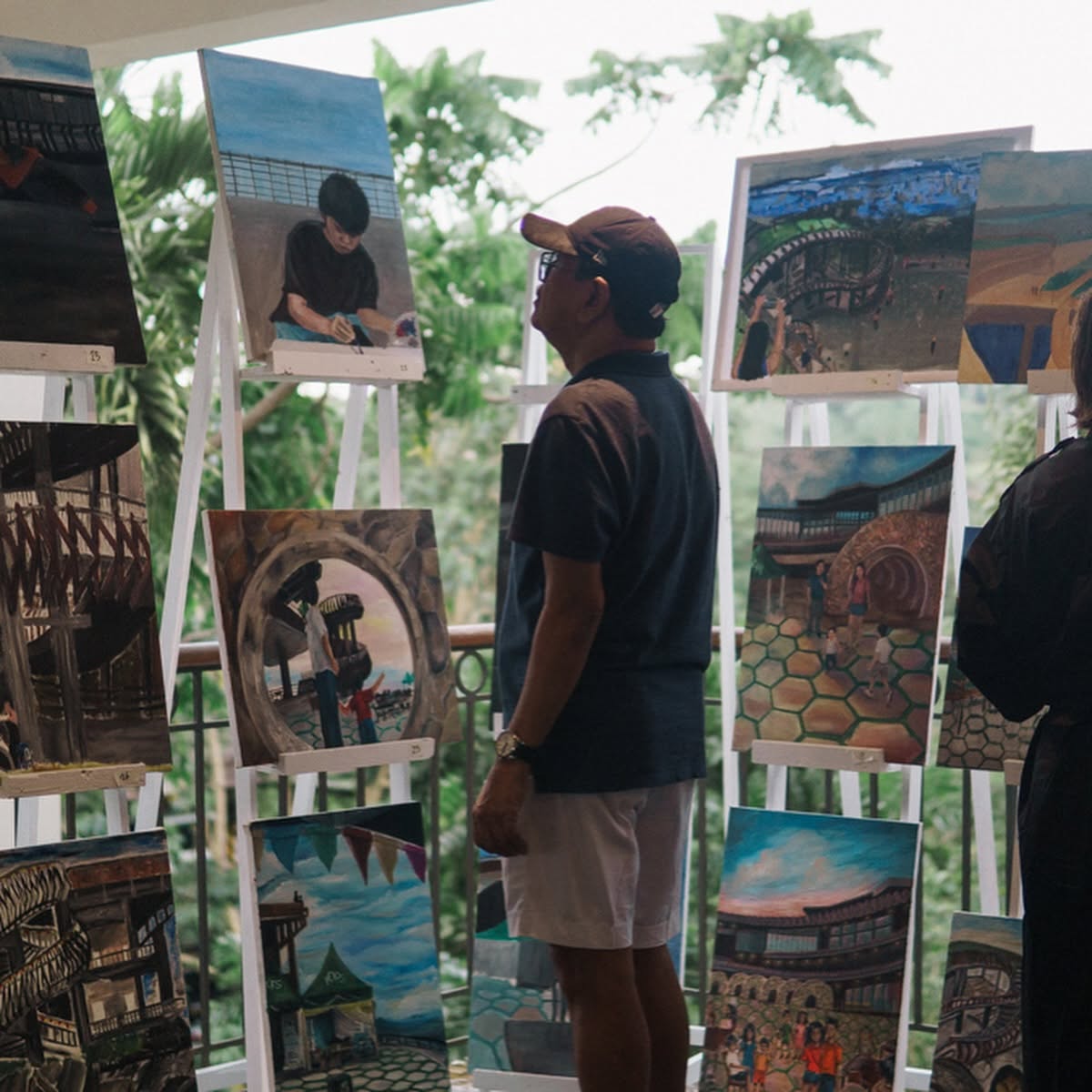 An artist looking at the artworks at TOPS Cebu.